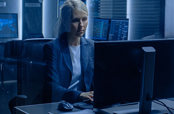 Photo of a woman working at a computer in a high-tech setting.